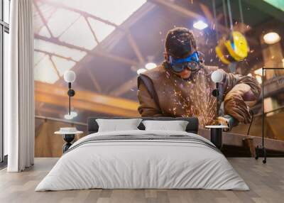 Young man with protective goggles welding in a factory Wall mural