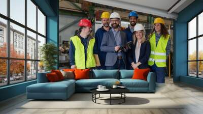 Young man worker with Down syndrome with manager and other collegues working in industrial factory, social integration concept. Wall mural