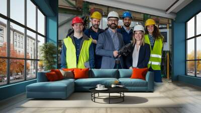 Young man worker with Down syndrome with manager and other collegues working in industrial factory, social integration concept. Wall mural