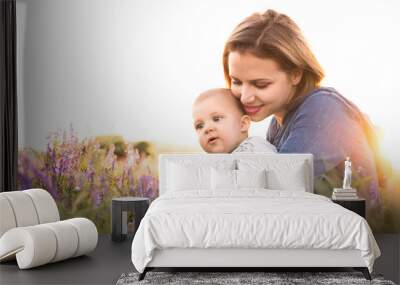 Young mother in nature with baby son in the arms. Wall mural