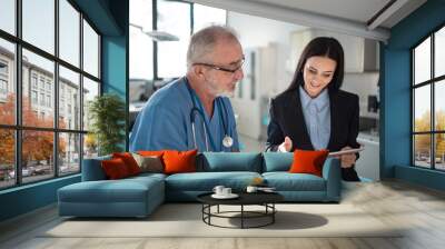 Young pharmaceutic seller explaining something to doctor in hospital. Wall mural