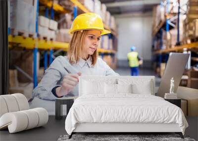 Young warehouse workers with laptop working. Wall mural