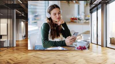 Young woman having distance education in her apartment. Wall mural