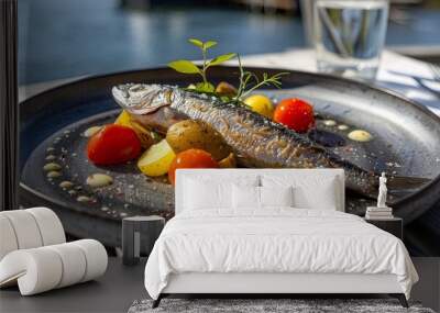 An image of fresh grilled sea bass with tomatoes and potato balls on a white plate. Wall mural