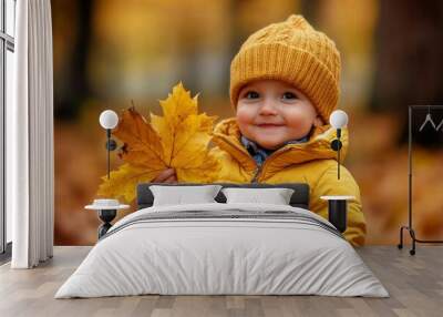 Laughing girl playing outdoors with old maple leaves and foliage, wearing warm yellow jacket, jeans, and rubber boots. Concept for fall family photography. Wall mural