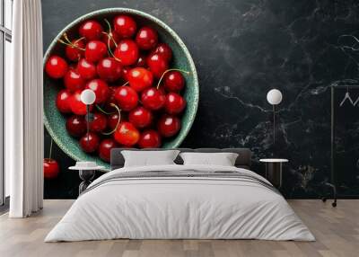 On a black background, cherry in a bowl, top view, copyspace Wall mural