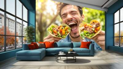 Young man smiling and eating a taco in a restaurant in a restaurant. Traditional Mexican or Spanish cuisine in a tortilla for a lunch meal. Wall mural