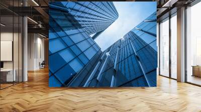 Bottom view of modern skyscrapers in business district against blue sky. Wall mural