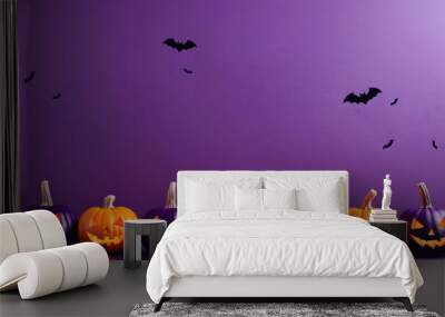 Colorful jack-o'-lantern pumpkins row against purple background with bats Wall mural