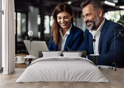 A photo of two business people smiling and working together on a laptop.  Wall mural