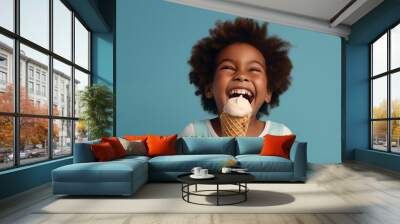 Cheerful kid eating ice cream in waffle cone isolated on blue. Wall mural