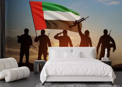 Silhouettes of soldiers with the flag of UAE on background of the sunset or the sunrise. Commemoration Day. Wall mural