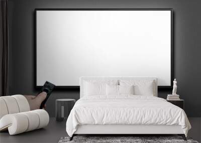 Television on a gray wall and remote control in hand. TV 4K flat screen lcd or oled, White blank HD monitor mockup. Modern video panel black flatscreen. Wall mural