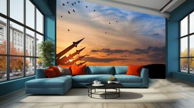 The missiles are aimed at the sky at sunset. Nuclear bomb, chemical weapons, missile defense, a system of salvo fire. Wall mural