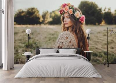 Woman wearing crocheted shawl and floral crown in a serene outdoor setting Wall mural