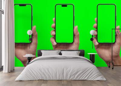 Hand holding smartphone set with green screen for VDO editor and modern frameless design in two rotated perspective positions - isolated on black background - Clipping Path	 Wall mural