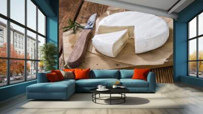 Pieces of Camembert on wooden background Wall mural