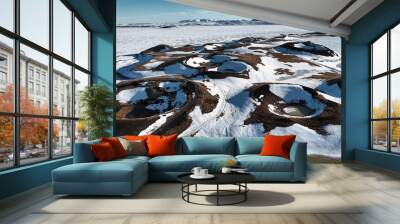 Surreal crater landscape covered with snow and ice and partially filled with water Wall mural