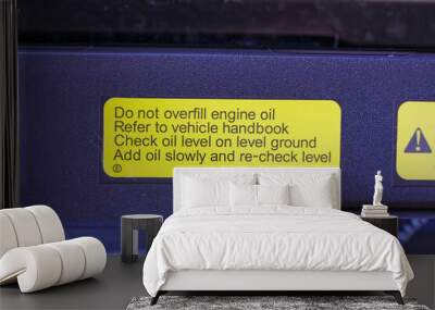 Engine oil warning sticker in the engine bay of a new car Wall mural