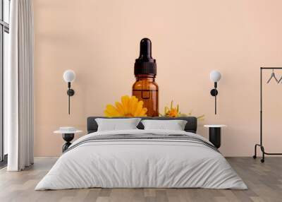 Dark cosmetic bottle of aromatic oil for herbal medicine with calendula flower on a beige backdrop with trendy shadows. Marigold extract. Wall mural