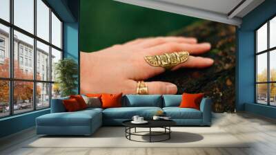 hand with rings lies on a tree Wall mural