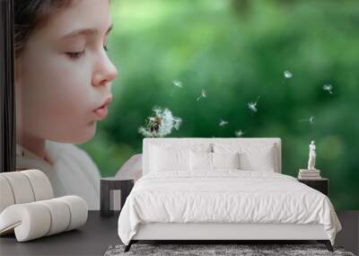 Kid girl blowing on a dandelion Wall mural