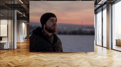 portrait of a handsome man in a field in winter at dawn Wall mural