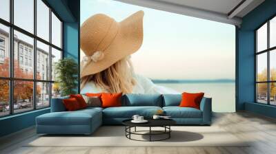 Portrait of young blond european woman in a straw hat with satin bow and white dress looking on a sea. Landscape background. Beautiful girl. Side view. Profile. Dreamed mood. International woman day Wall mural