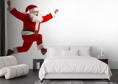 Santa Claus joyfully jumping in a festive pose on a plain background during the holiday season Wall mural