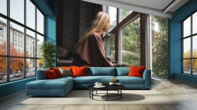 teenager girl with long blonde hair sits on a windowsill Wall mural