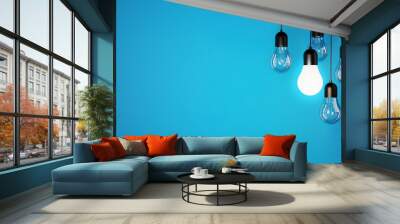 The concept of a light bulbs on blue background, place for text and design, light bulbs background Wall mural