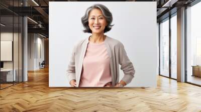 Portrait of a happy mature asian businesswoman standing against white background Wall mural