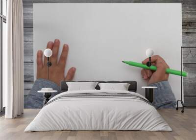 child holding pen on blank sheet of paper. kid draws on white paper. Wall mural