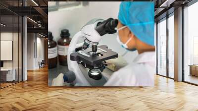 Asian technician tests the quality of product in laboratory closeup Wall mural