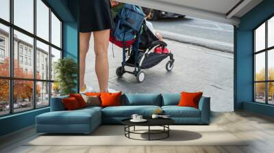 Young mother with her baby stroller with busy city traffic Wall mural