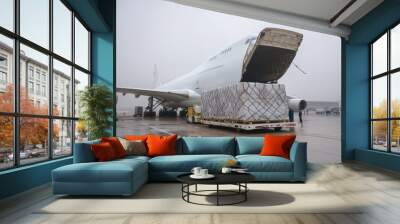 Cargo plane being loaded with large packages. Wall mural