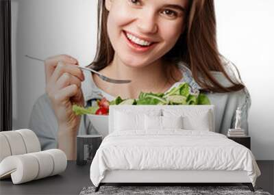 a happy young woman eating healthy salad with spoon on white background, in the style of light gray and light crimson, youthful, isolated, png, cutout Wall mural