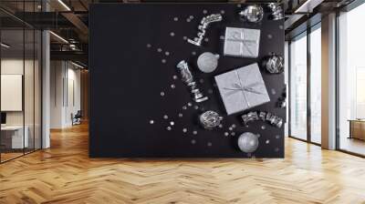 Present boxes, silver christmas balls and ribbons on black background with copy space Wall mural