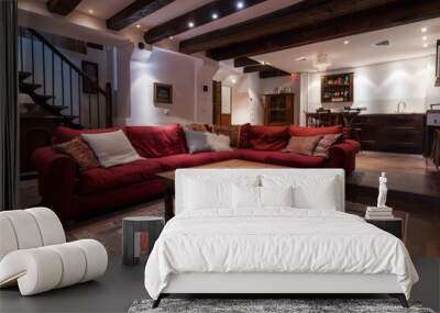 A modern basement loft with exposed wooden beams and a red sectional sofa Wall mural