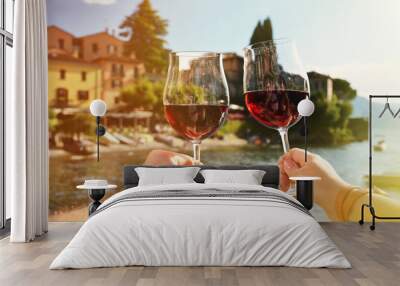 two wineglasses in the hands. varenna town at the lake como, ita Wall mural