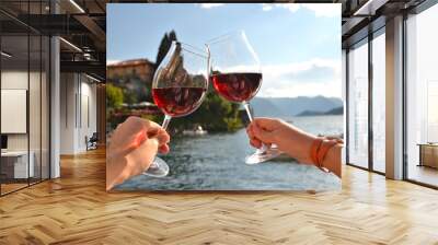 Two wineglasses in the hands Wall mural