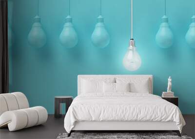 Hanging light bulbs with glowing one different idea on light blue background , Minimal concept idea , flat lay , top Wall mural