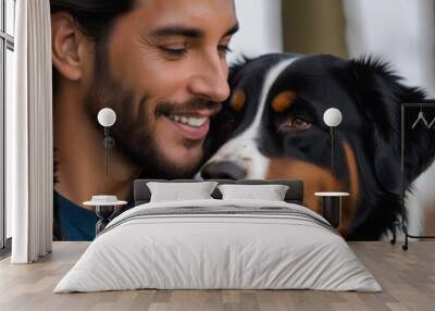 Young man poses with his Australian Shepherd dog in the garden and hugs him affectionately Wall mural