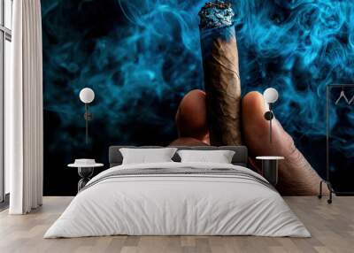 A person holding a cigar in their hand with smoke coming out of it Wall mural