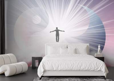 A silhouette of a man with arms spread apart, flying in the sky in a bright white sunlight on the background of the Yin-Yang symbol. Samadhi meditation concept, open mind. Wall mural