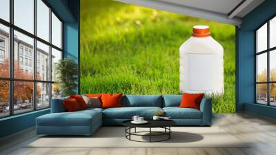 Blank plastic bottle with pest poison on green grass. Garden insecticide, toxic liquid substance. Wall mural