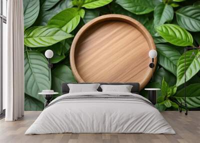 Empty round wooden podium with green leaves. Wood round board. Flat lay, top view. Close-up. Wall mural