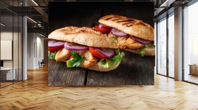 Gourmet grilled chicken sandwiches with fresh lettuce, juicy tomatoes, and red onions on baguette Wall mural