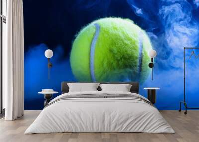 Green tennis ball in blue smoke. Sport game concept. Close-up. Wall mural