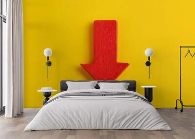 Red wooden arrow pointing down on yellow background. Business, market decline or economic Wall mural